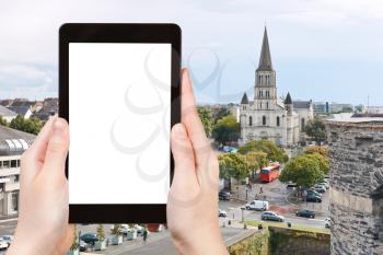 travel concept - tourist photograph cityscape with St Laud's Church in Angers, France on tablet pc with cut out screen with blank place for advertising logo
