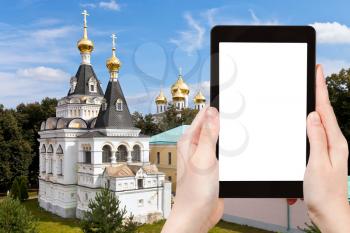 travel concept - tourist photograph old churches and historical buildings of Dmitrov Kremlin, Moscow region, Russia on tablet pc with cut out screen with blank place for advertising logo