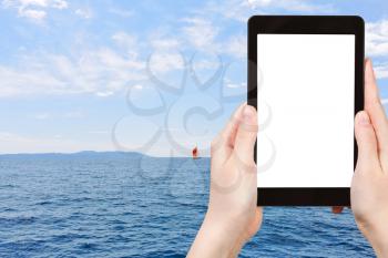 travel concept - tourist photograph red yacht in blue Adriatic sea, Dalmatia, Croatia on tablet pc with cut out screen with blank place for advertising logo