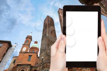 travel concept - tourist photograph palace and two towers in Bologna, Italy on tablet pc with cut out screen with blank place for advertising logo