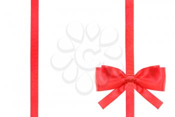 one red satin bow in lower right corner and two vertical ribbons isolated on horizontal white background