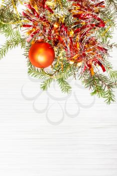 Christmas greeting card - border from one gold Xmas ball and tree branch on blank paper background