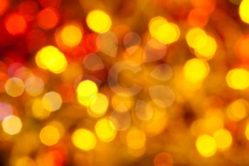 abstract blurred background - brown, yellow and red twinkling Christmas lights of electric garlands on Xmas tree