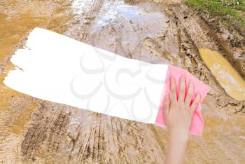 weather concept - hand deletes dirty country road by pink rag from image and white empty copy space are appearing