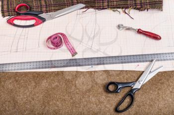 dressmaking still life - top view of cutting table with tissue, pattern, tailoring tools
