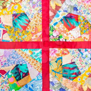 four details of hand made patchwork quilt framed in red cloth