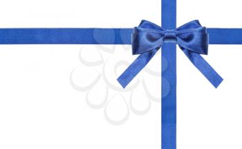 one blue satin bow in upper right corner and two intersecting ribbons isolated on horizontal white background