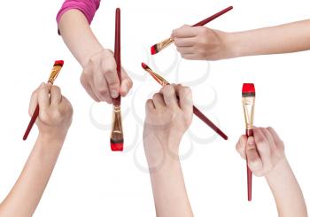 set of hands with flat art paintbrushes with red painted tips isolated on white background