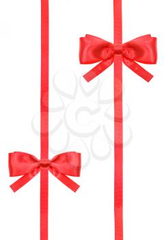 two red satin bows and two vertical ribbons isolated on vertical white background