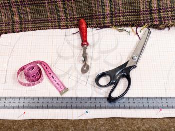 dressmaking still life - top view of cutting table with material, pattern, tailoring tools