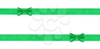 two little green bow knots on two parallel silk ribbons isolated on white background