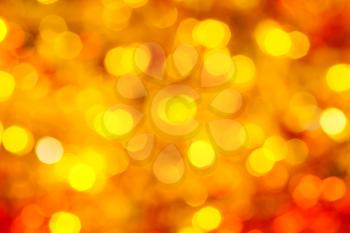 abstract blurred background - yellow and red flickering Xmas lights bokeh of garlands on Christmas tree