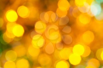 abstract blurred background - yellow and green dark flickering Christmas lights bokeh of electric garlands on Xmas tree