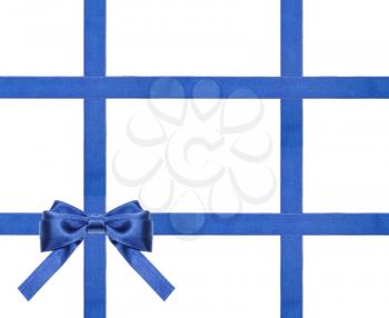one blue satin bow in upper left corner and four intersecting ribbons isolated on horizontal white background