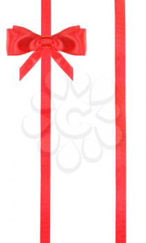 one red satin bow in upper left corner and two vertical ribbons isolated on vertical white background