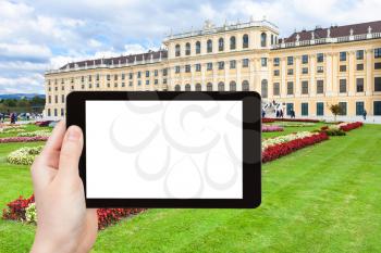 travel concept - tourist photographs of lawn in Schloss Schonbrunn palace in Vienna on tablet pc with cut out screen with blank place for advertising logo
