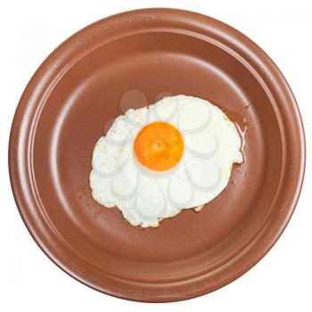above view of fried egg on brown ceramic plate isolated on white background