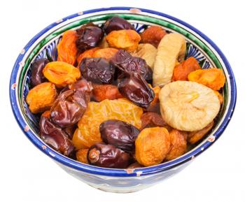 Central Asian dried fruits in traditional ceramic bowl isolated on white background