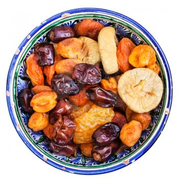 above view of Central Asian dried fruits in typical ceramic bowl isolated on white background