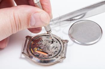 Repairing of watch - horologist replaces battery in quartz wristwatch close up