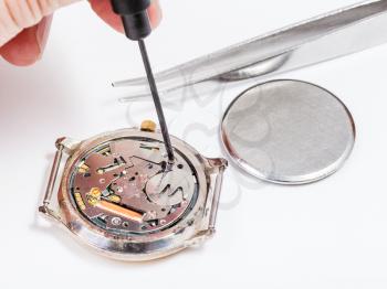 Repairing of watch - watch repairer replaces battery in quartz wristwatch close up