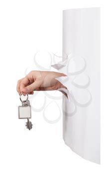 side view of hand holds the keyring through a hole in a sheet of paper isolated on white background