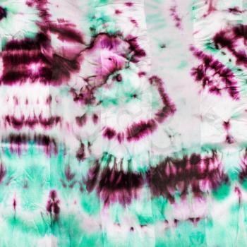 textile background - abstract hand painted magenta and green spots on nodular batik