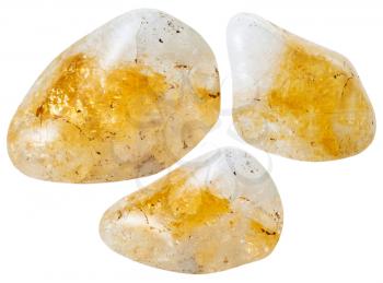 macro shooting of natural mineral stone - three yellow citrine quartz gemstones isolated on white background