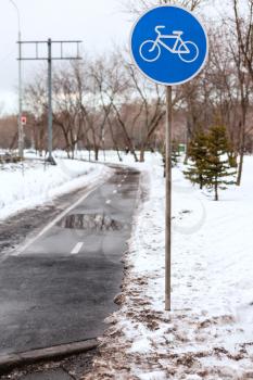 wet bicycle lane in city in bad weather in winter season