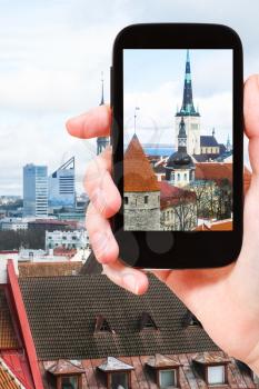 travel concept - tourist photographs cathedrals in Tallinn city, Estonia on smartphone