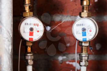 cold and hot residential water meters on pipes