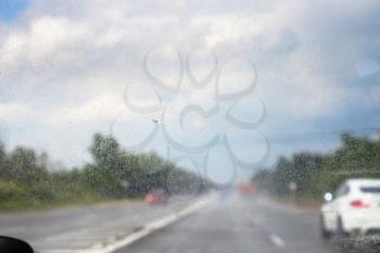 raindrops on windscreen during driving car in rain ( (focus on glass)
