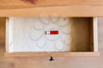 top view of little red flash drive in open drawer of nightstand