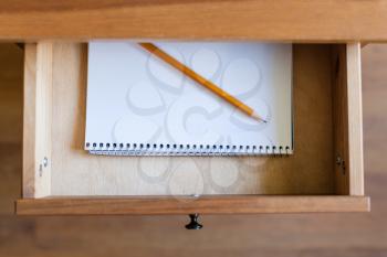 top view of pencil on album for drawing in open drawer of nightstand