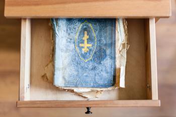 top view of shabby ritual book in open drawer of nightstand