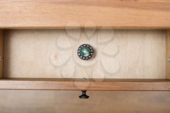 top view of vintage little silver casket with gem on cover in open drawer of nightstand