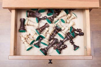 above view of chess pieces in open drawer of nightstand