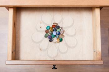 above view of pile of gem stones in open drawer of nightstand