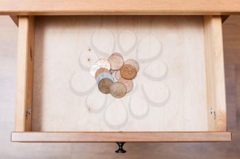 above view of several of british coins in open drawer of nightstand