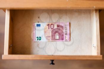 above view of ten euro banknote in open drawer of nightstand