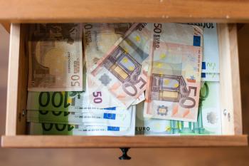 above view of many euro banknotes on bottom of open drawer of nightstand
