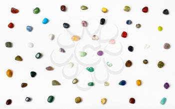 many natural mineral semi-precious stones arranged on white background