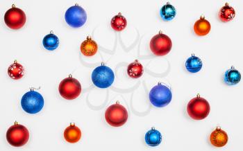 many blue, red, orange christmas balls on white background