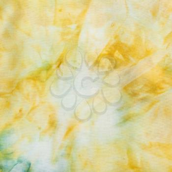 textile background - abstract yellow colored silk batik