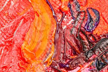 macro shooting of red and yellow oil paint brush strokes on canvas close up
