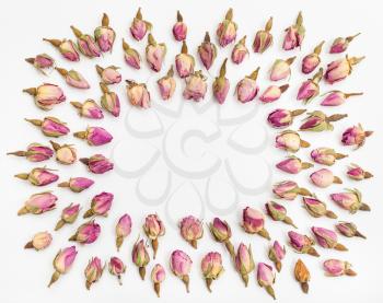 frame from many natural pink rose flower buds on white textured paper background