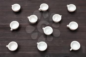 food concept - above view of many white cups on dark brown table
