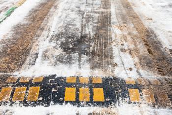 speed bump in snow on urban road in winter day