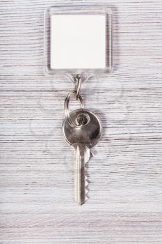 door key with white blank keychain on wood table