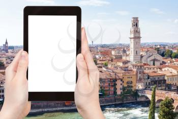 travel concept - tourist photographs Verona city on tablet with cut out screen with blank place for advertising in Italy